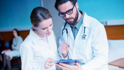 женщина и мужчина врач смотрят в журнал